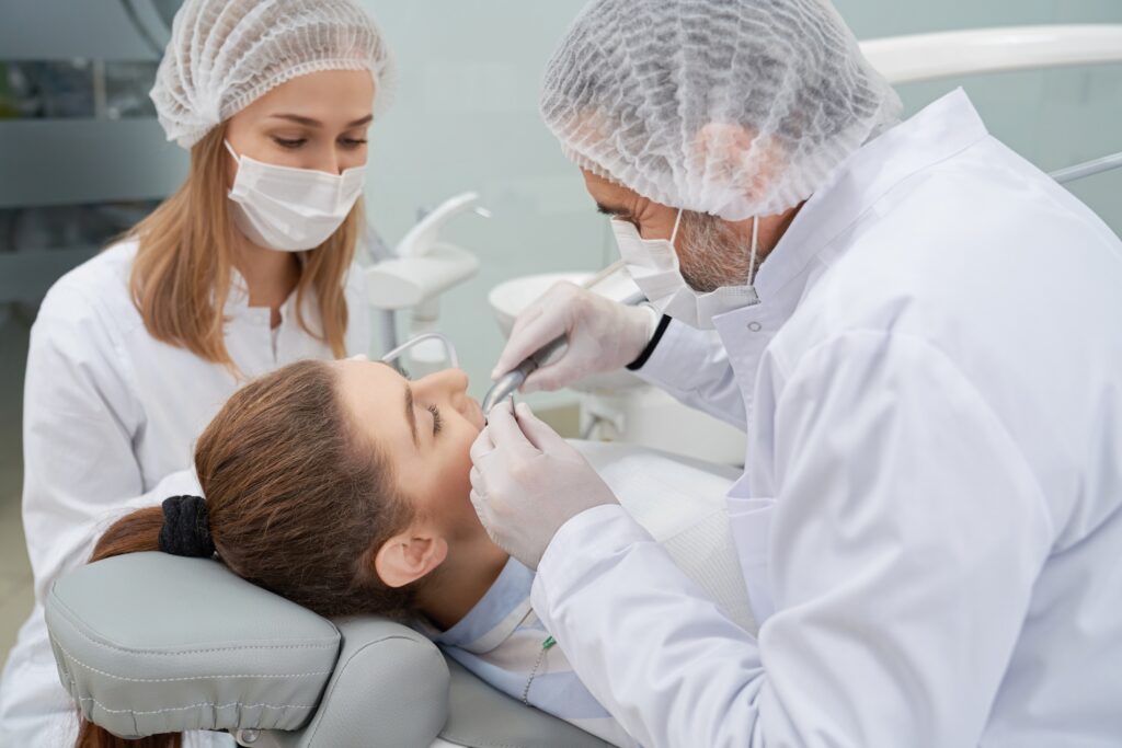 Dentist and assistant having woman's teeth done.