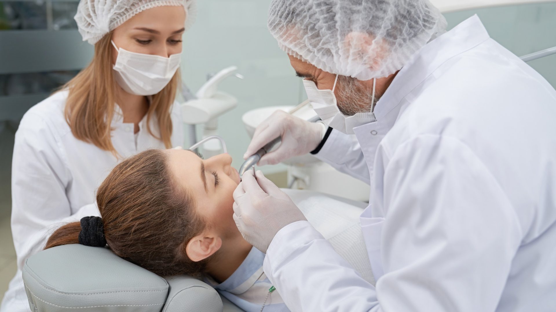 Dentist and assistant having woman's teeth done.